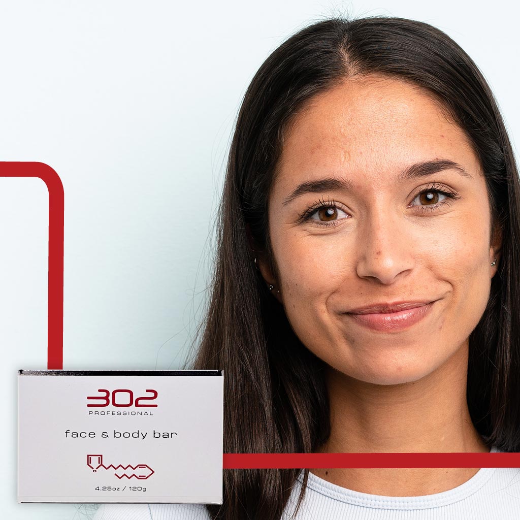 BAR-425OZ_WOMAN_6_1024x1024_72 | 302 Professional Skincare Smiling woman with a white box labeled '302 Professional face & body bar' held near her shoulder, with red decorative lines in the background.