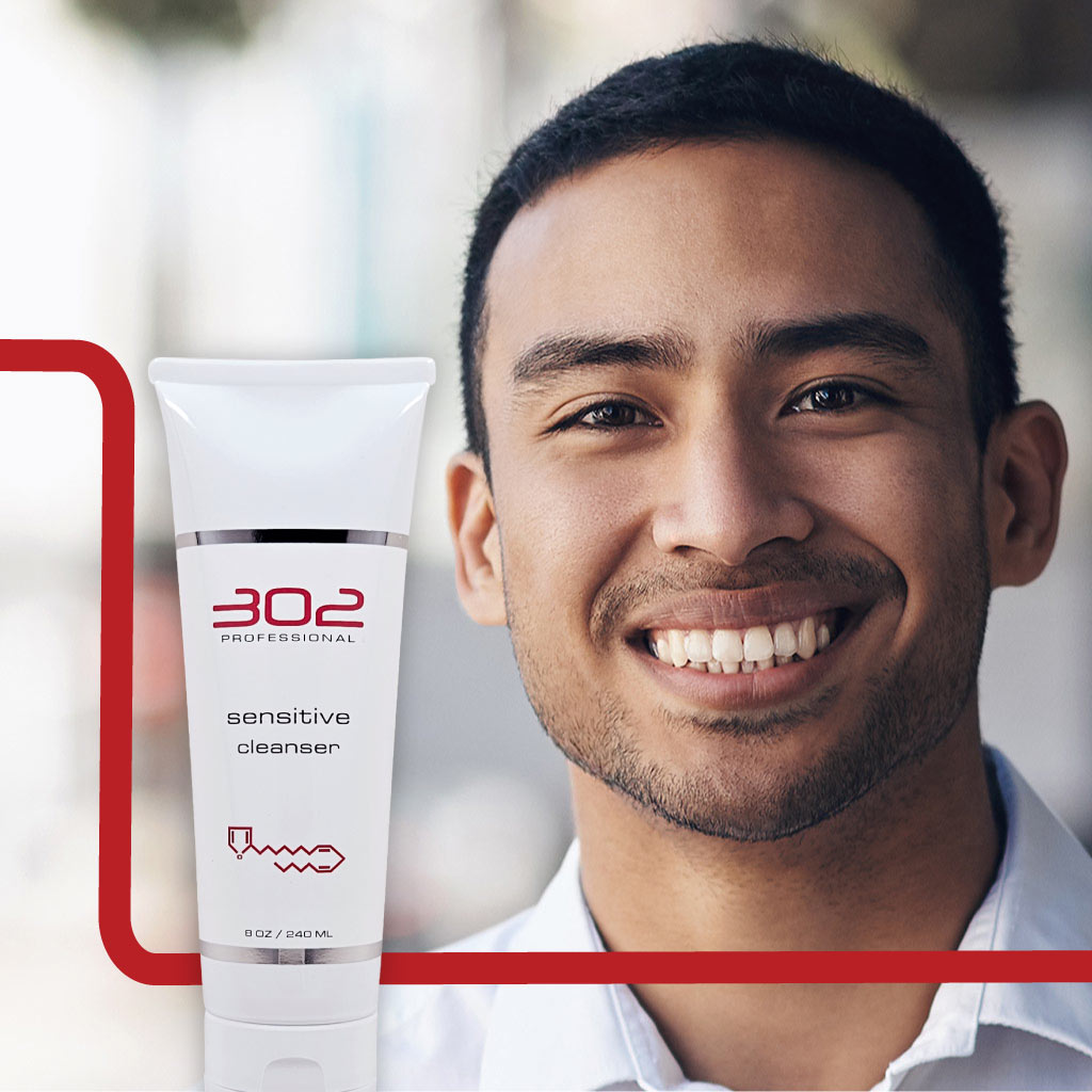 SENSITIVE-CLEANSER-8OZ_MAN_2_1024x1024_72 | 302 Professional Skincare Smiling man with a white tube labeled '302 Professional Sensitive Cleanser' in the foreground.
