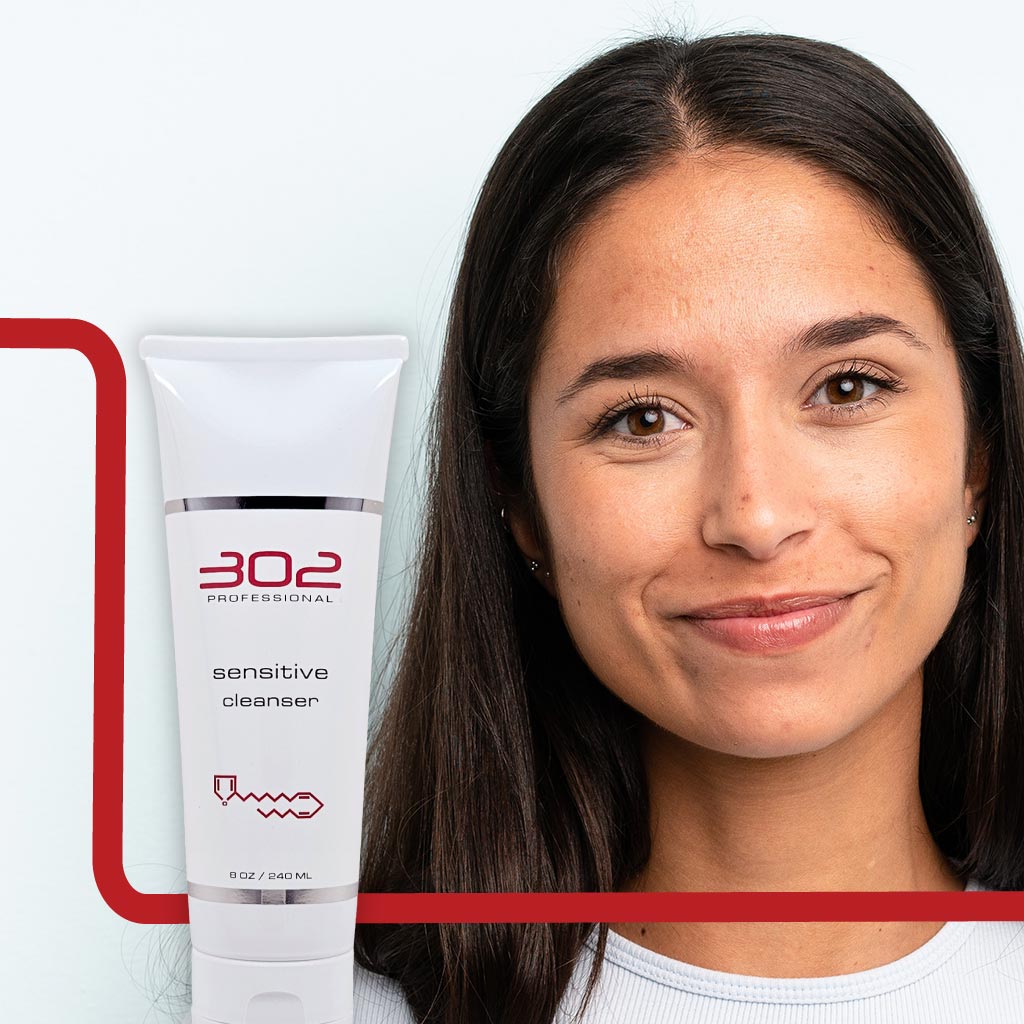 SENSITIVE-CLEANSER-8OZ_WOMAN_6_1024x1024_72 | 302 Professional Skincare Smiling woman with a white 302 Professional Sensitive Cleanser tube beside her, against a light background with red graphic framing edge.